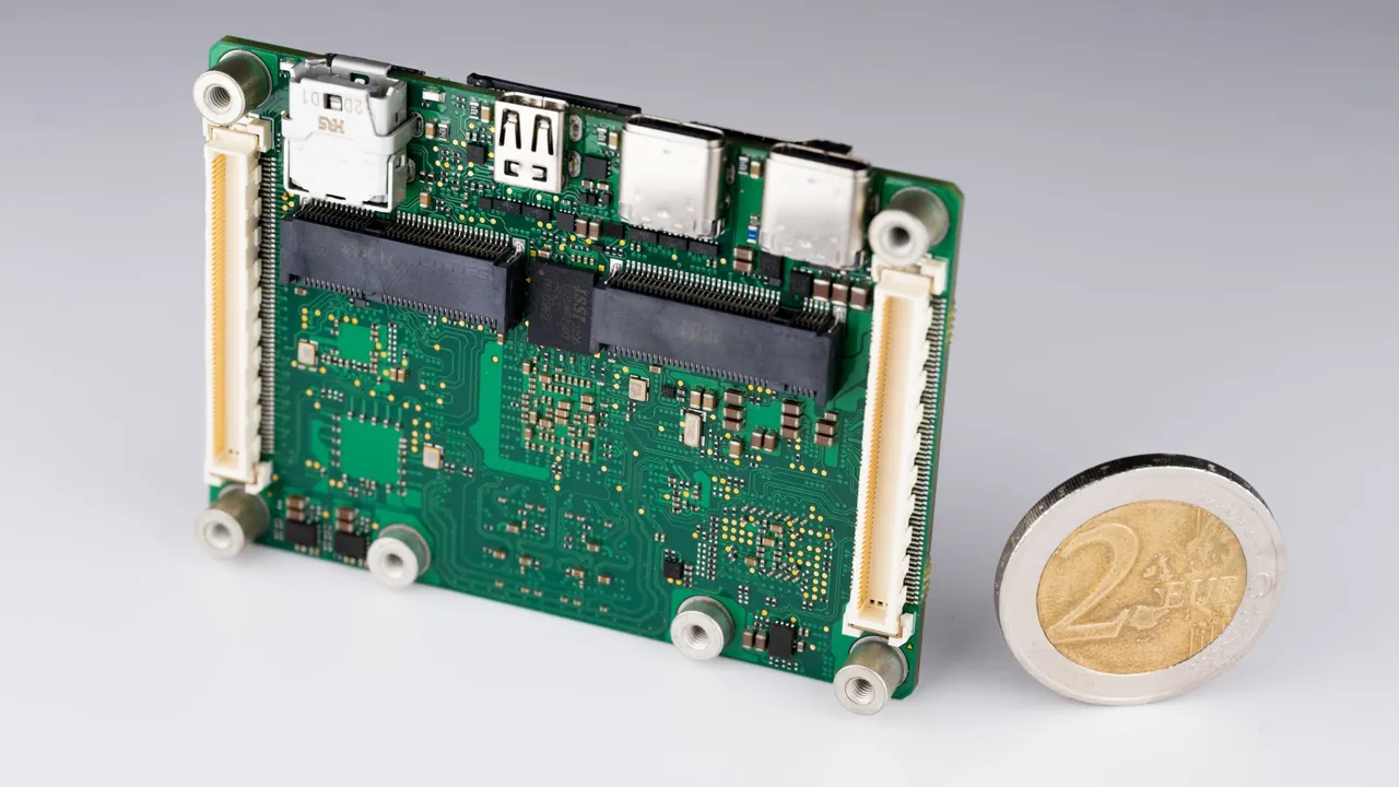 A compact assembled board beside a coin for scale